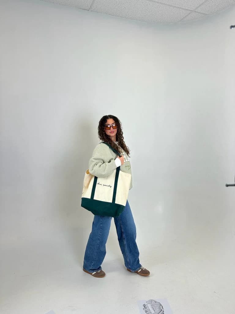 Full-length studio shot: the crewneck and the tote worn with jeans